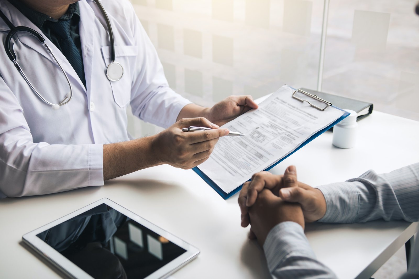 Doctor Is Writing The Appointment Letter To The Patient At The Clinic